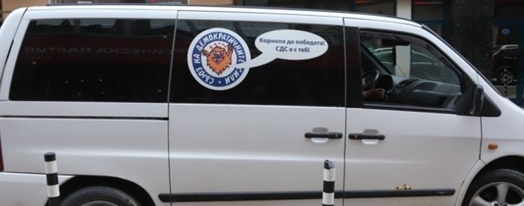 Бус с логото на СДС и надпис "Корнеля до победата! СДС е с теб!“ паркира на "Позитано" 20